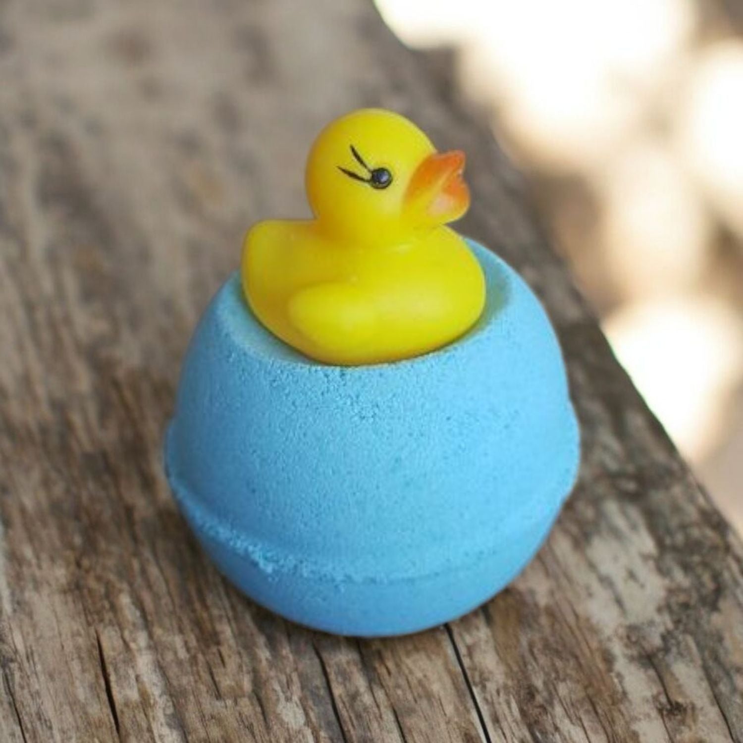 Blue Bath Bomb with a little Rubber Duck Bath Toy sitting on top